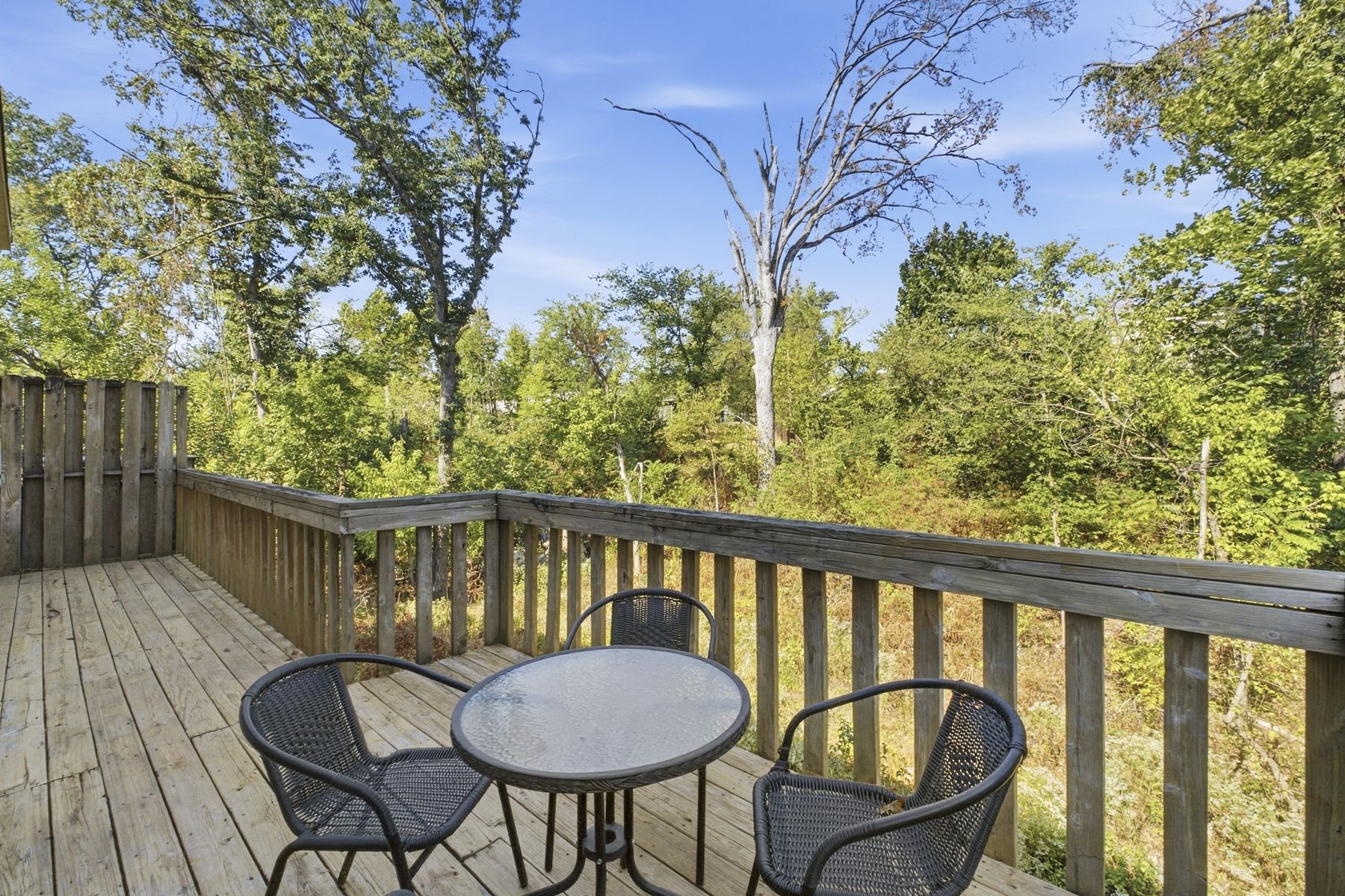 The Hideaway's rear deck with a bistro table over the wooded ravine