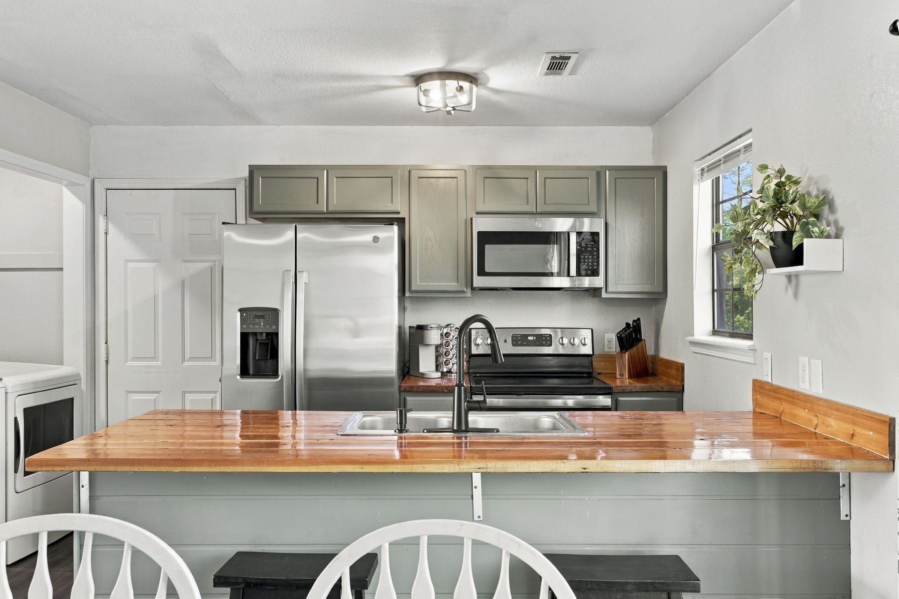 The Hideaway kitchen with sage green cabinets and a butcher block bar
